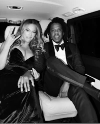 a black and white photo of a man and woman sitting in a car
